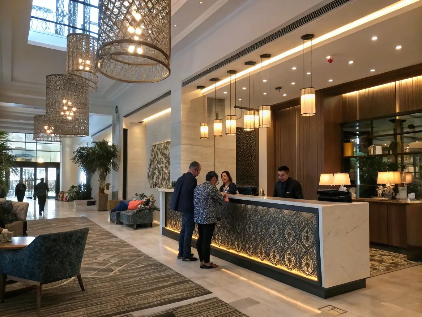 A modern hotel lobby featuring a MONSTER CHARGE station near the reception desk, emphasizing its availability for guests needing a quick power boost.